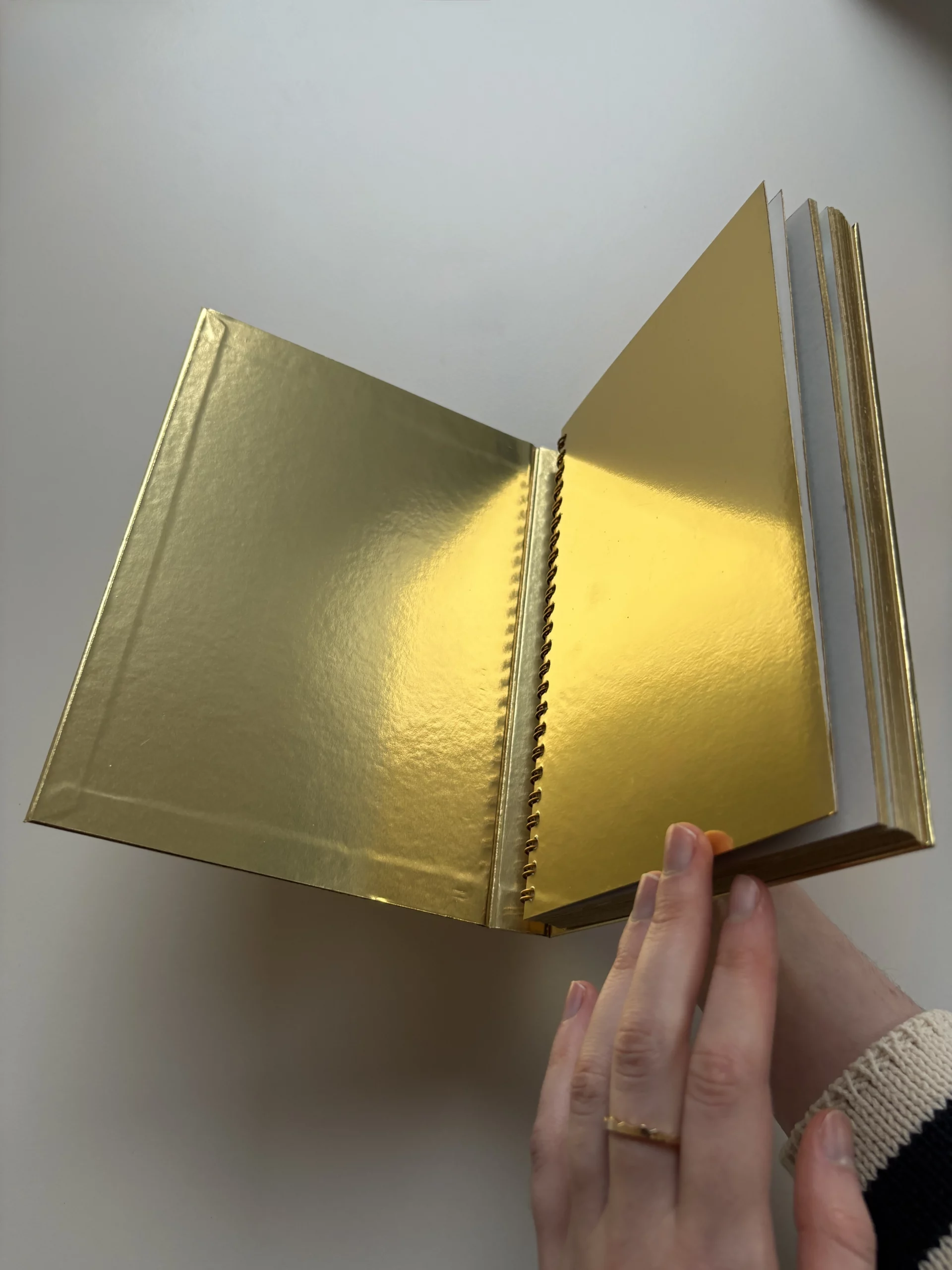 Memo_book with a mirror gold foil hardcover and matching gold-coloured edges.